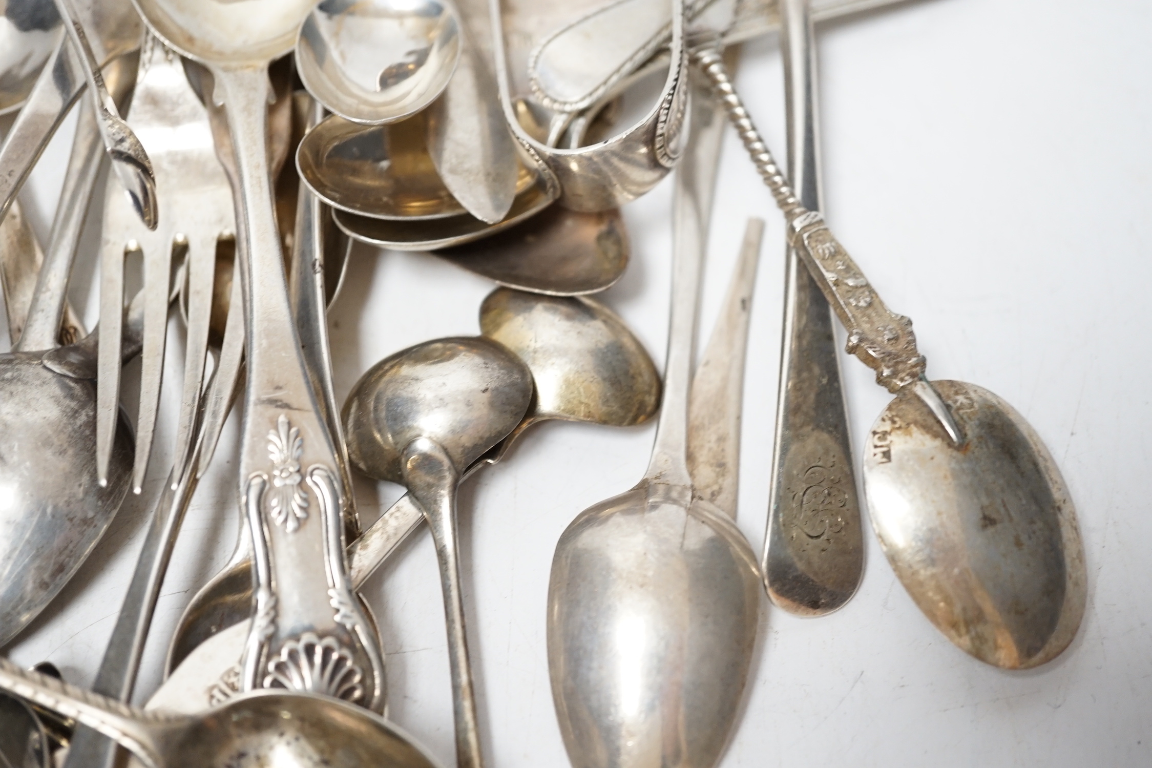 A small quantity of assorted 19th century and later silver flatware, two white metal spoons and a Victorian 'Rum' wine label, 18.2oz.